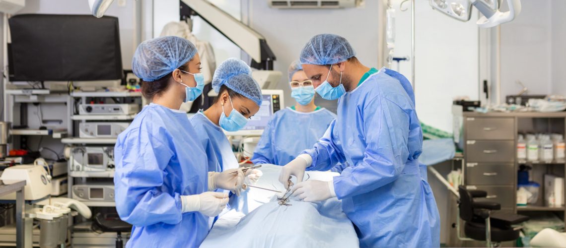 Team of professional doctors performing operation in surgery room. Medical Team Performing Surgical Operation in Bright Modern Operating Room
